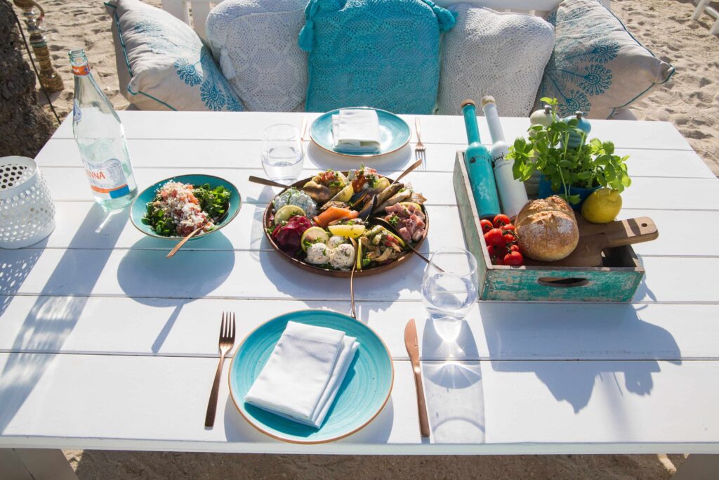 Outdoor dining table set up on a sandy shore in the best season for a Dubai trip.