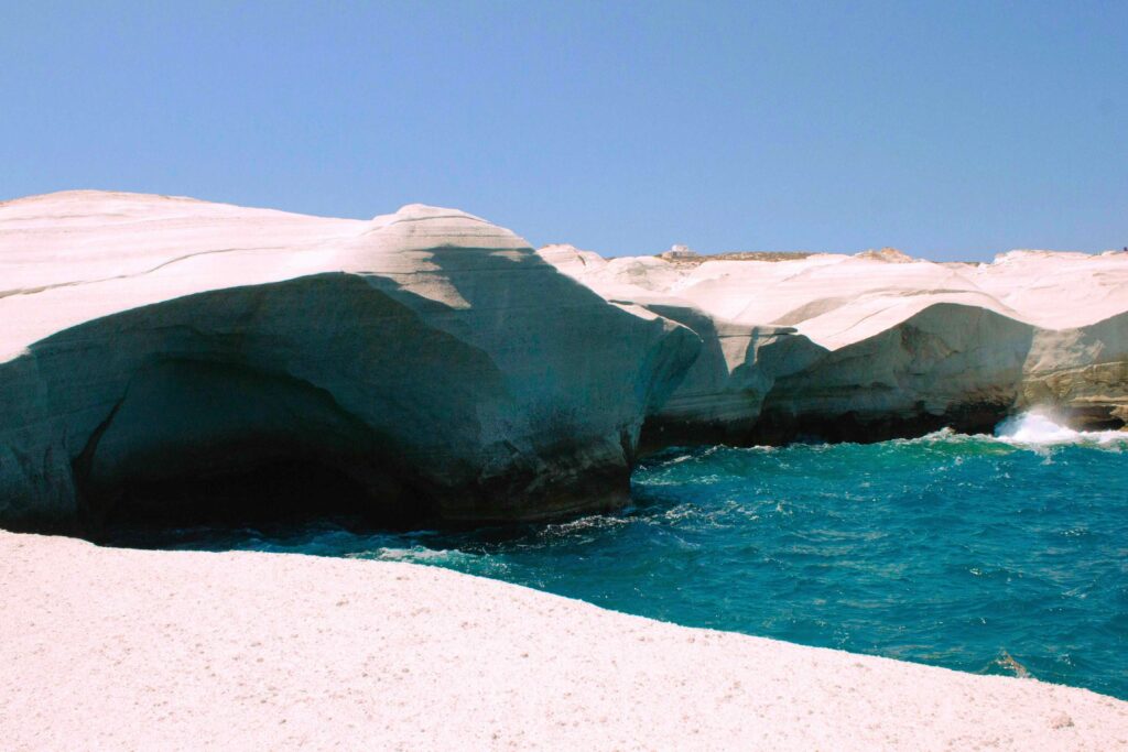 White volcanic rock cliffs forming a unique bay on Greek islands beaches.