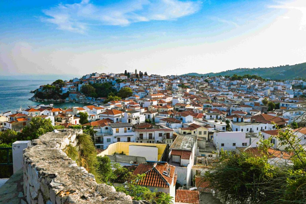 Coastal village with red tiled roofs along the blue sea for Greece island count.