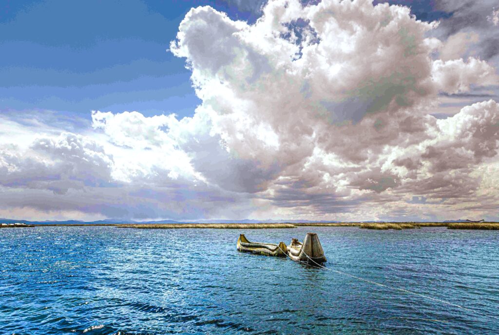 Traditional reed boats floating under dramatic cloudy sky on Lake Titicaca.