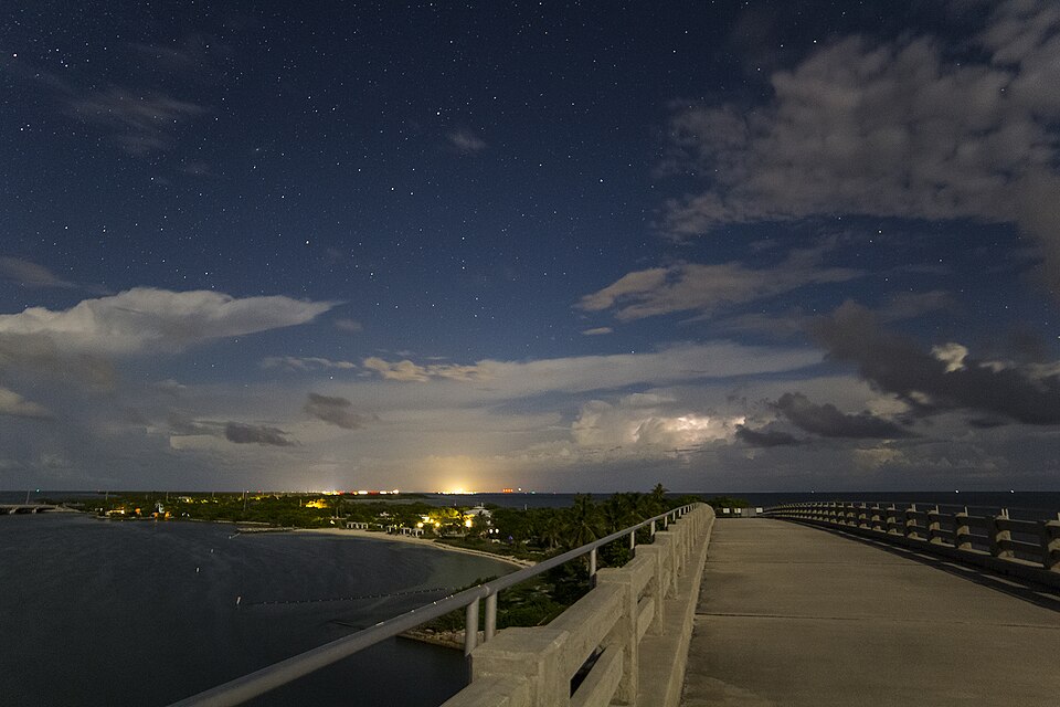 A historic railroad bridge in turquoise waters at night ocean camping.