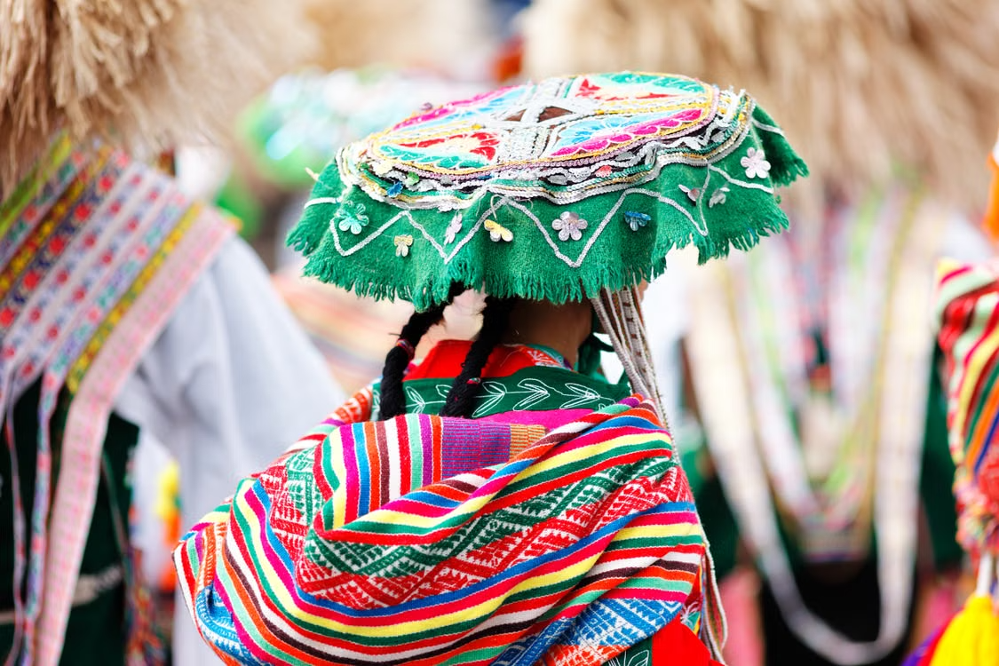 Traditional colorful Andean woven hat and garments worn during top time to visit Peru.