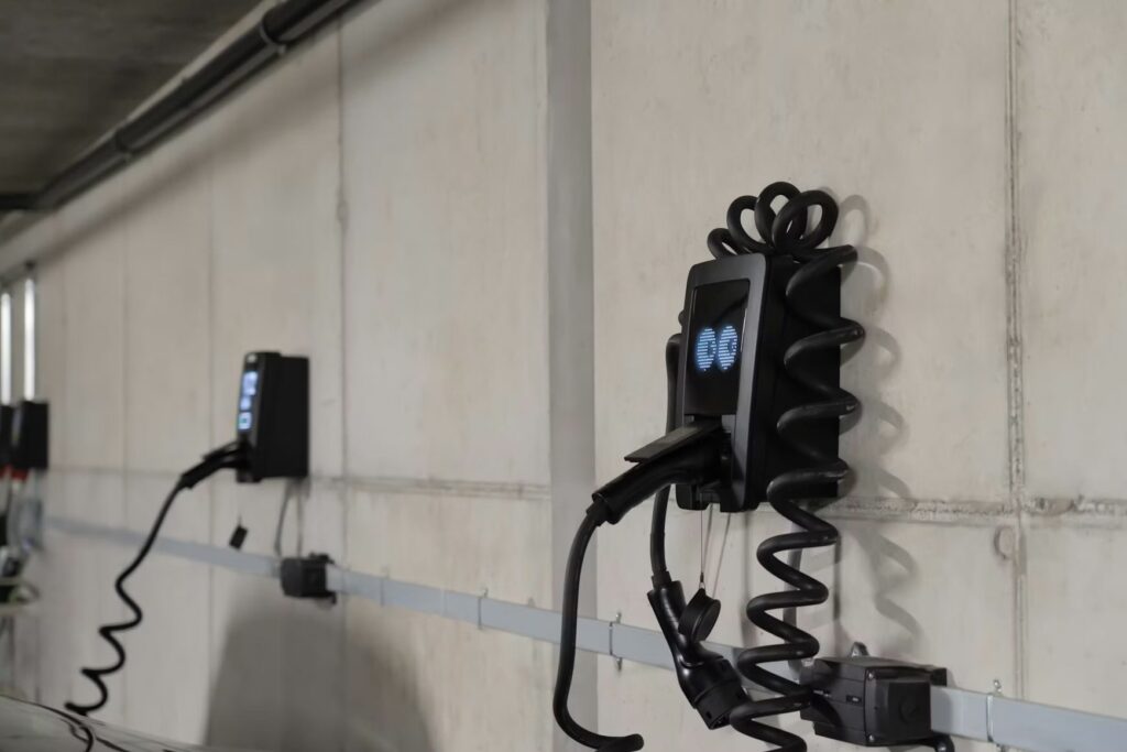EV charging stations mounted on a wall inside the parking garage. - Source: Unsplash